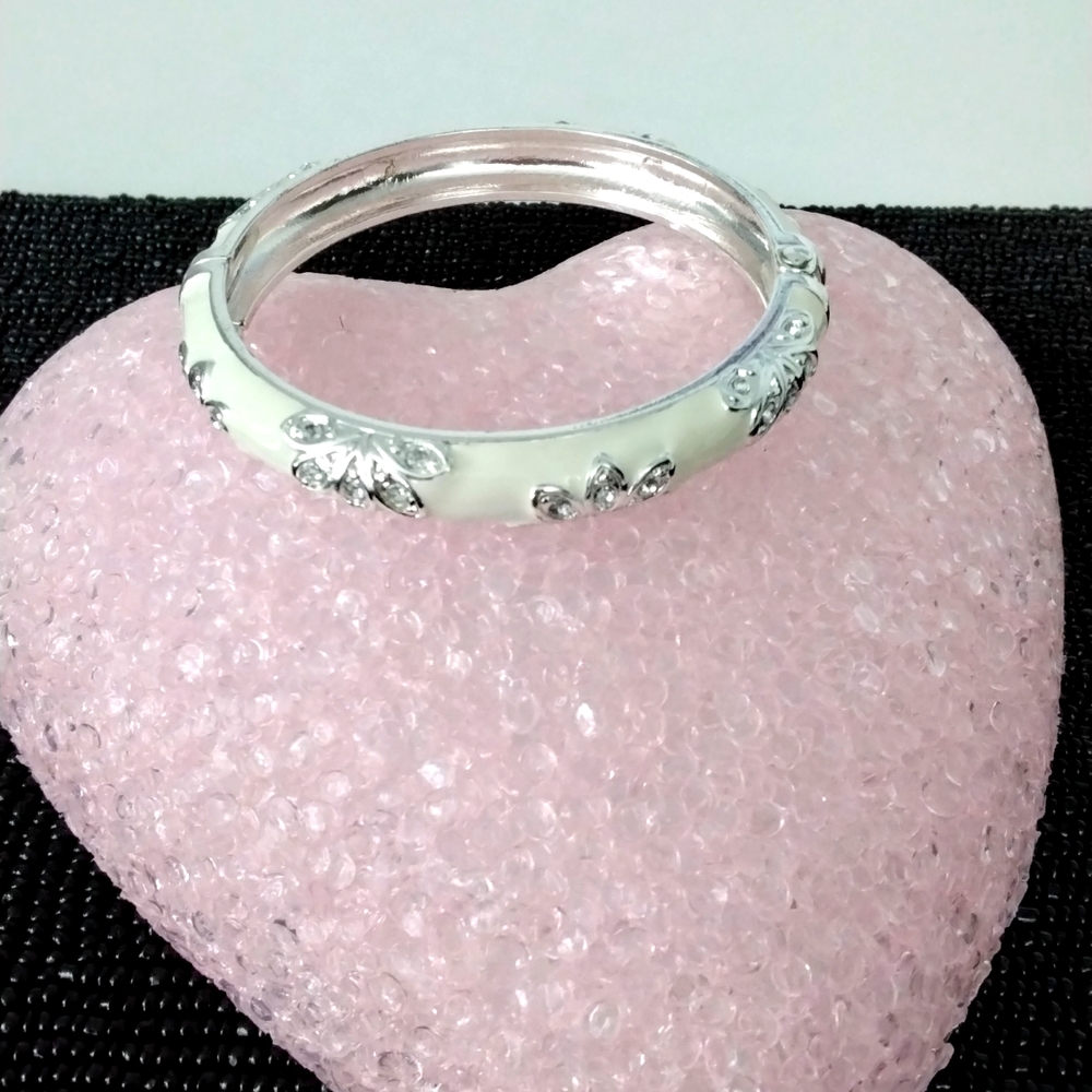 Ivory look hinged bracelet with silvertone and rhinestone detailing